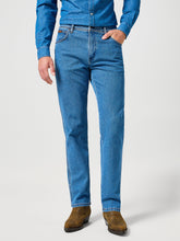 Person wearing blue jeans and a matching shirt on a white background