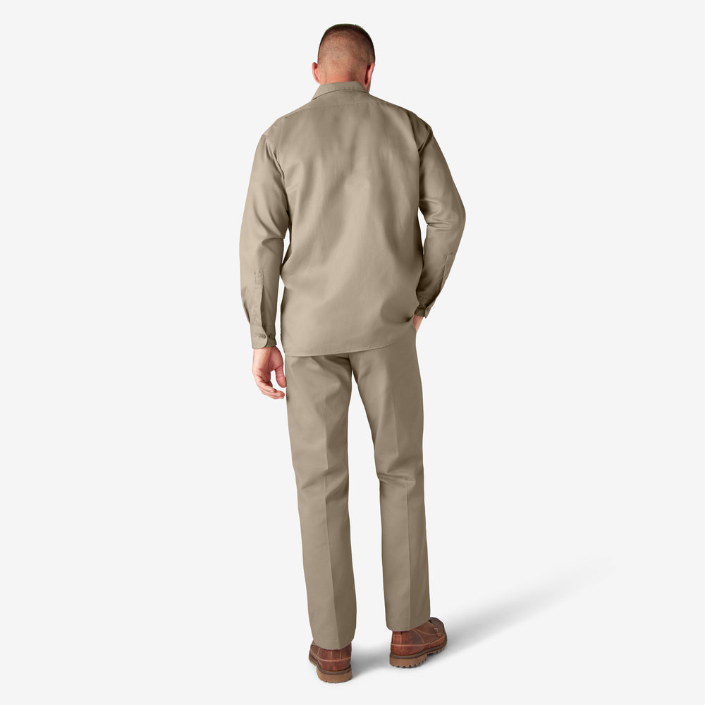Man wearing a beige suit standing against a white background