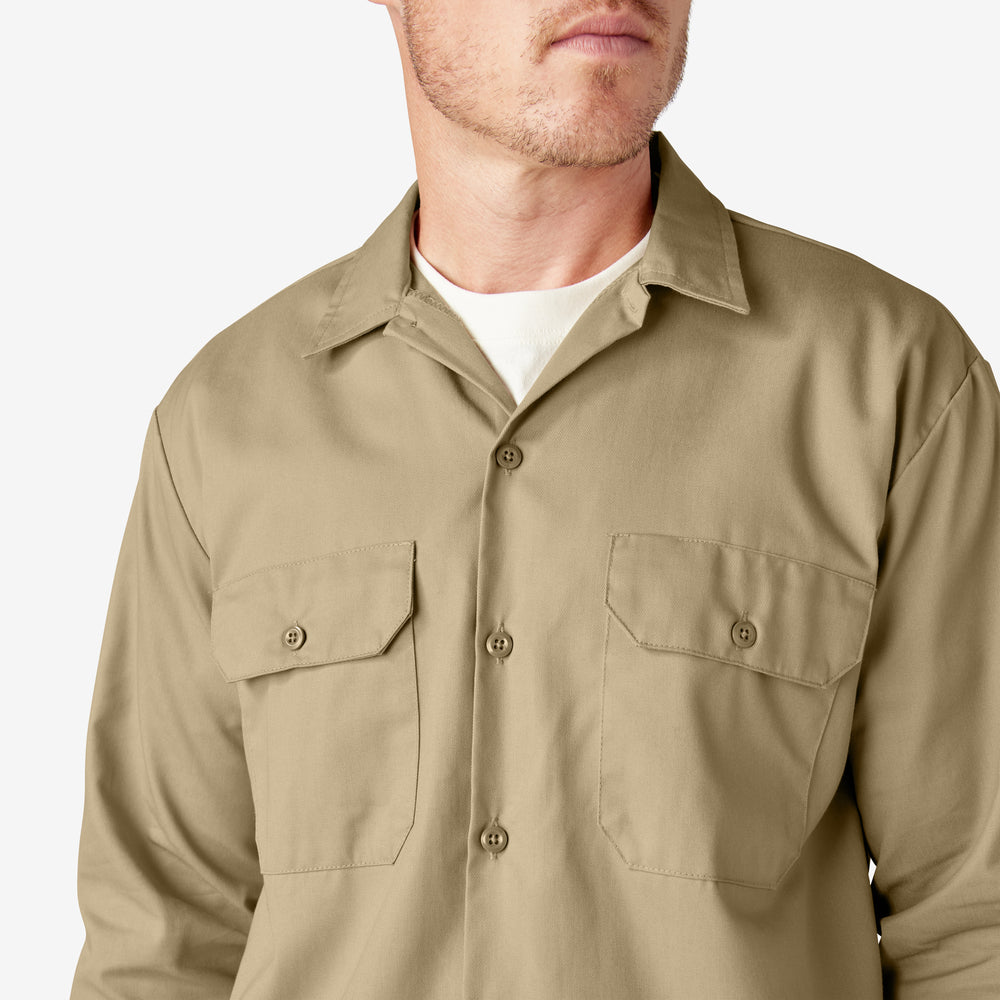 Man wearing a beige shirt with two front pockets on a light gray background