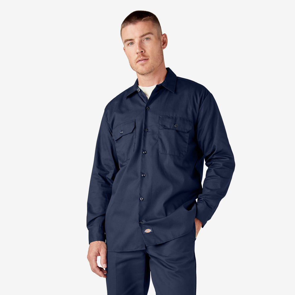 Man wearing a navy work shirt and pants on a white background