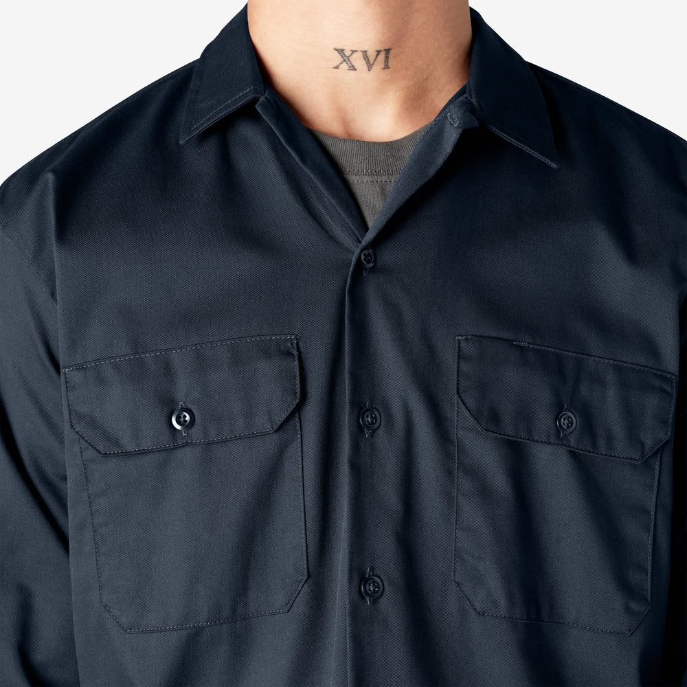 Dark blue shirt worn by a person with a visible tattoo on a plain background