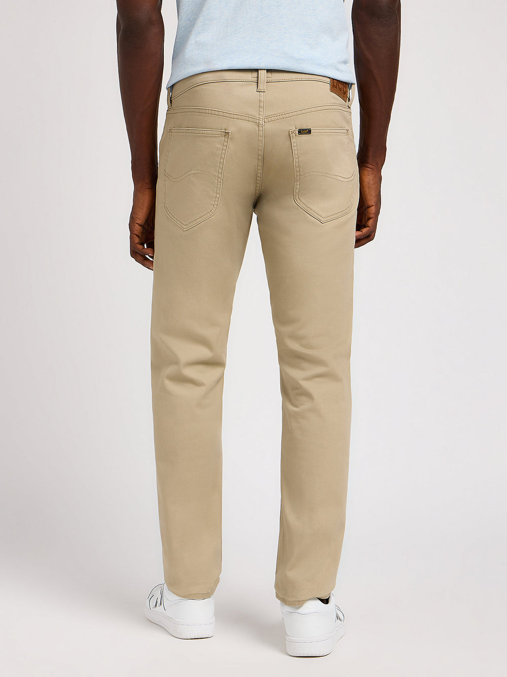 Person wearing beige pants on a white background