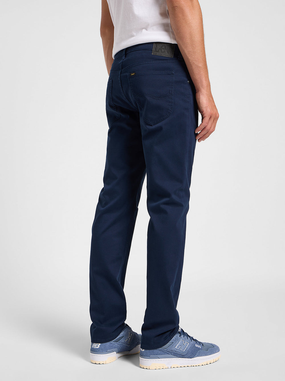 Person wearing navy pants on a white background