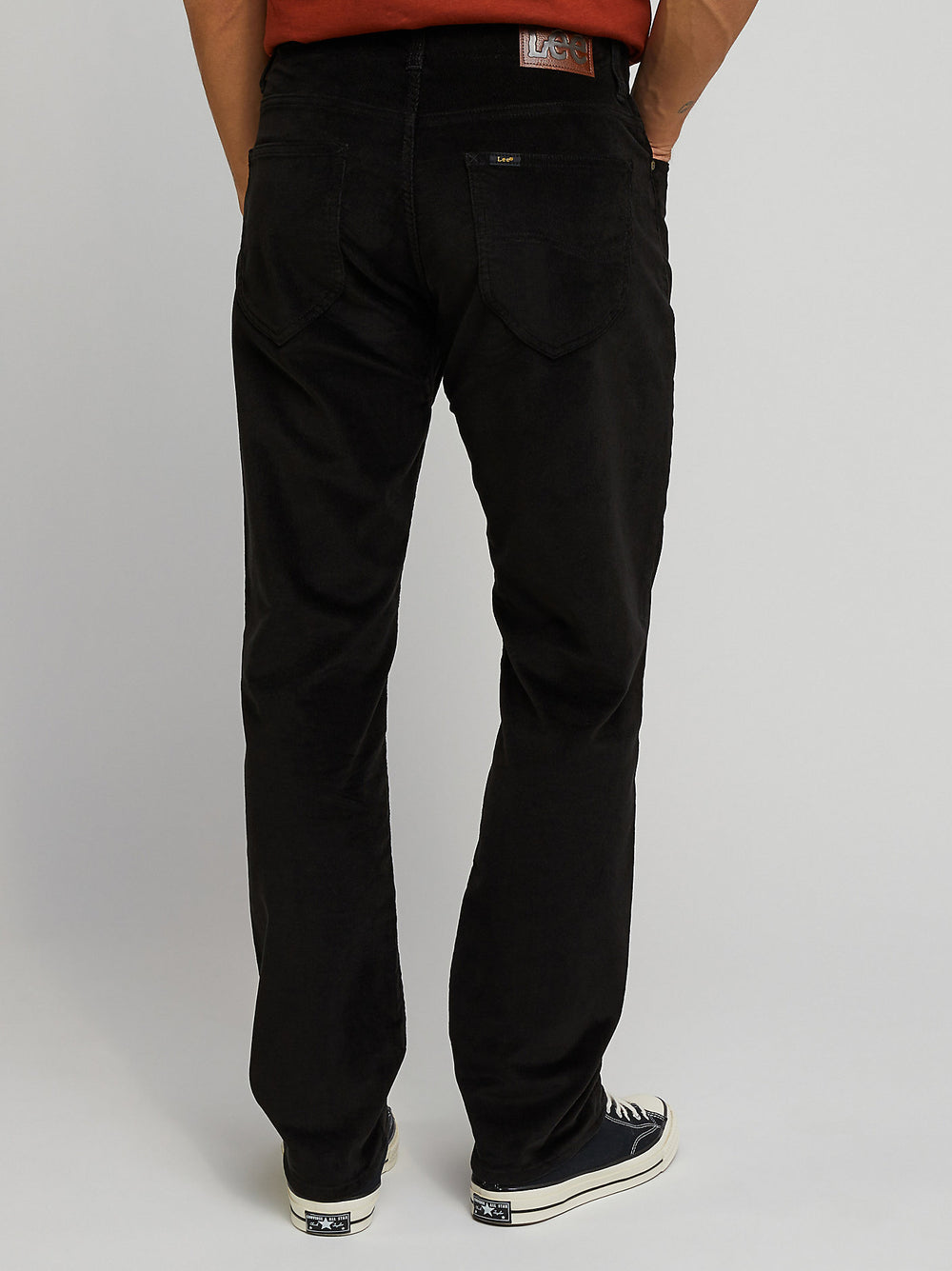 Person wearing black pants on a plain background