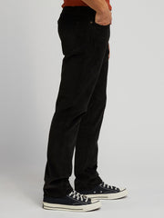 Person wearing black pants and black sneakers on a plain background