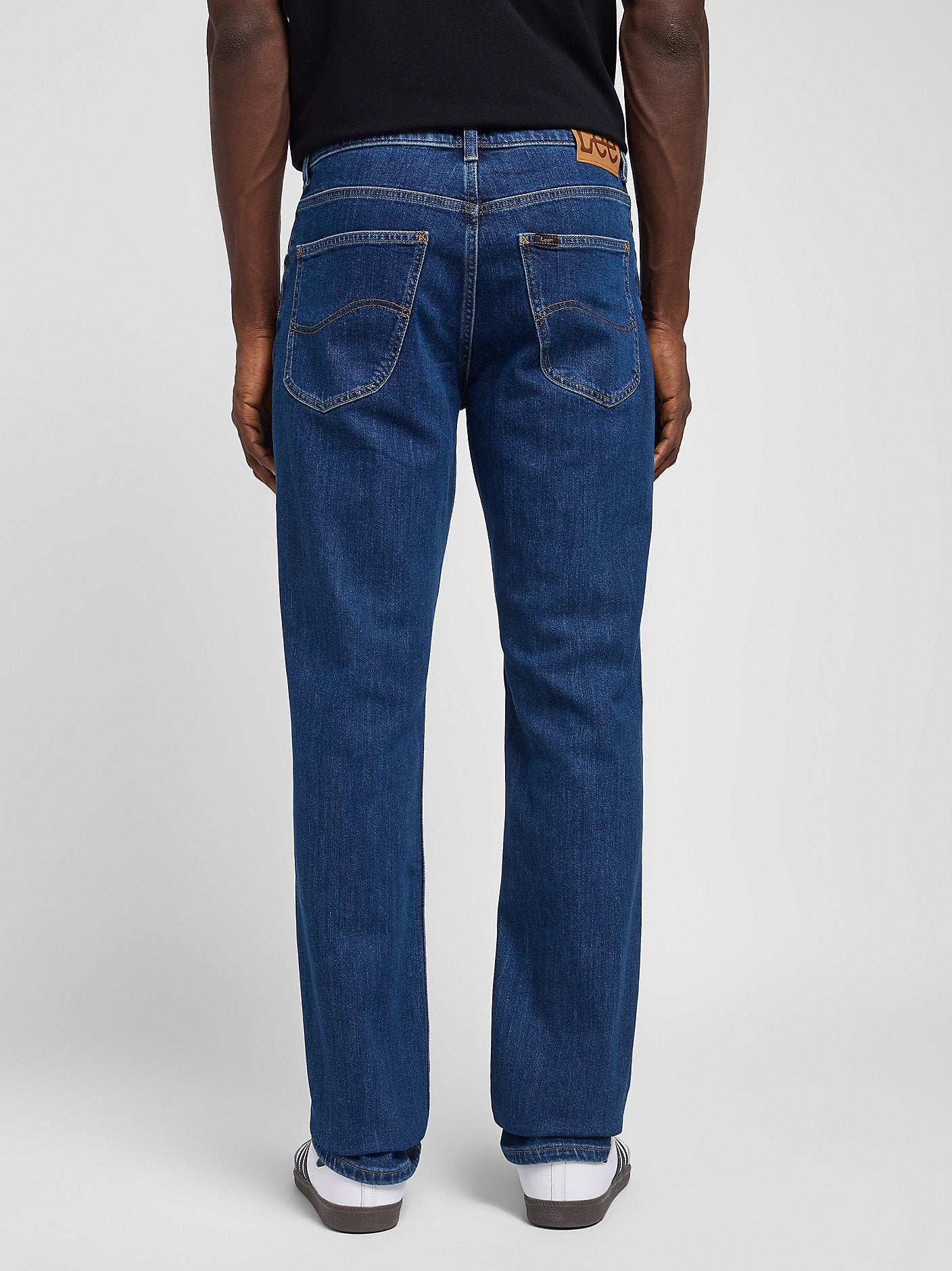 Person wearing blue jeans on a white background