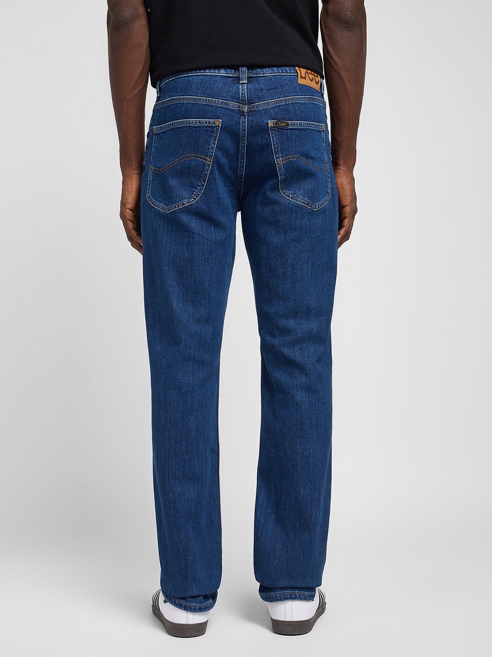 Person wearing blue jeans on a white background