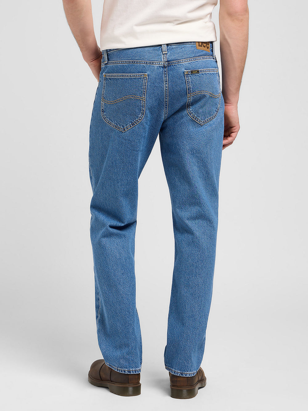 Person wearing blue jeans on a white background