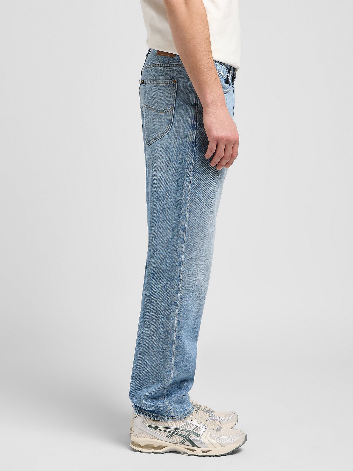 Light blue jeans worn by a person on a white background
