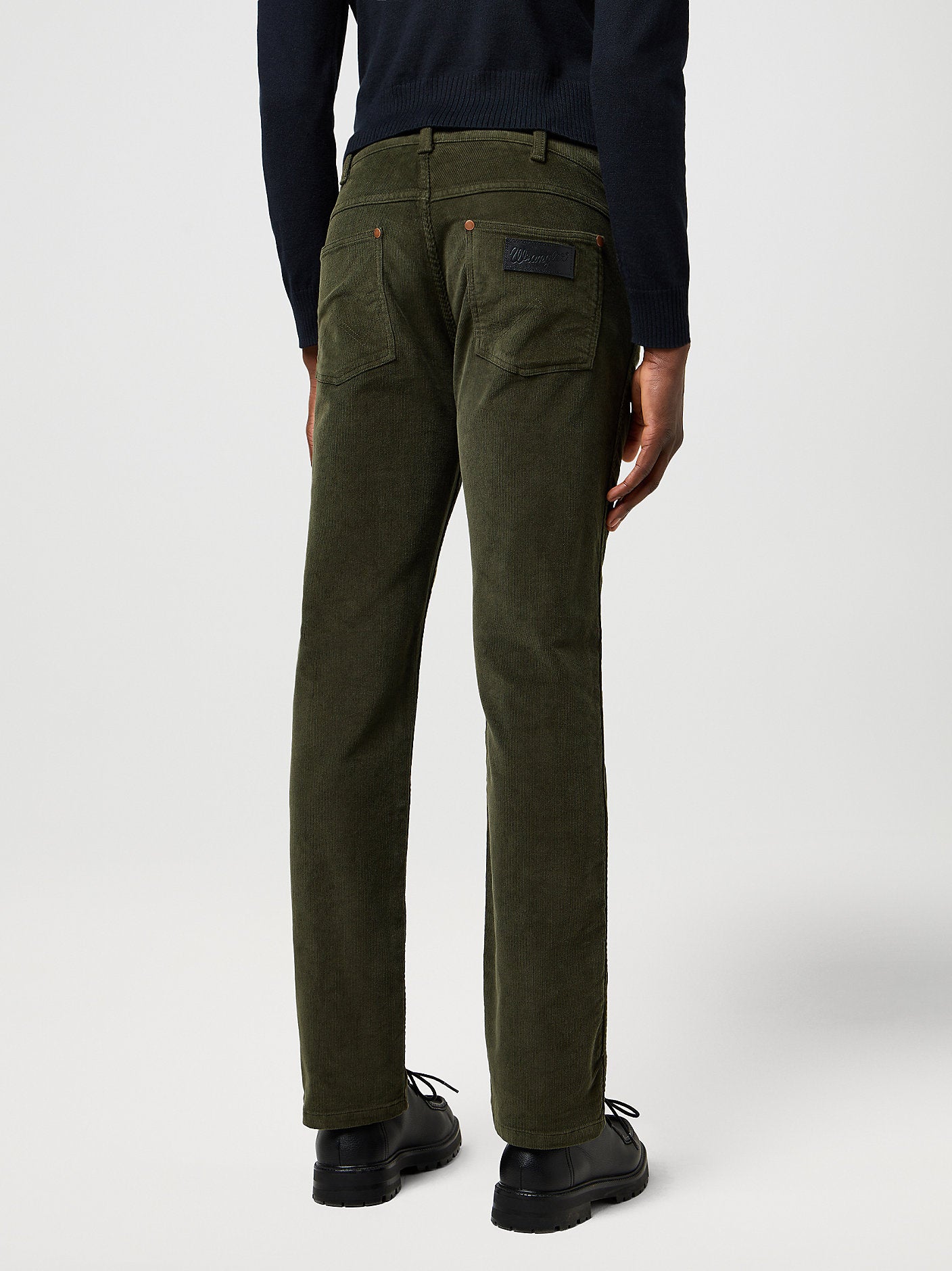 Person wearing olive green pants on a white background
