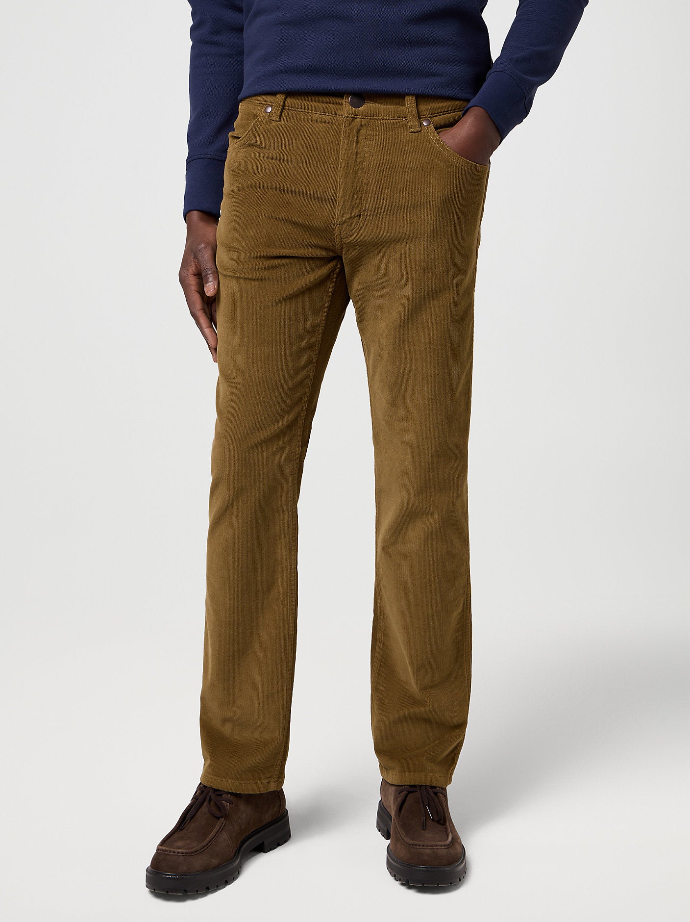 Person wearing brown corduroy pants on a white background
