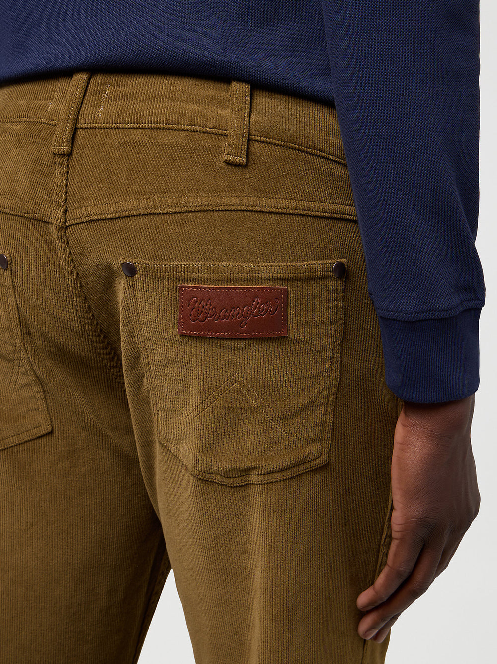 Brown corduroy pants with a Wrangler patch on a white background