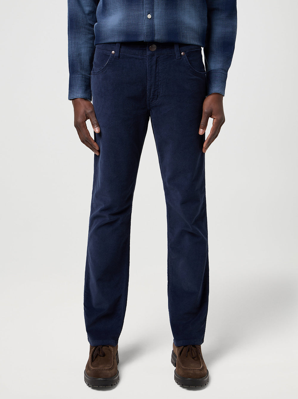 Person wearing navy pants with a plain background