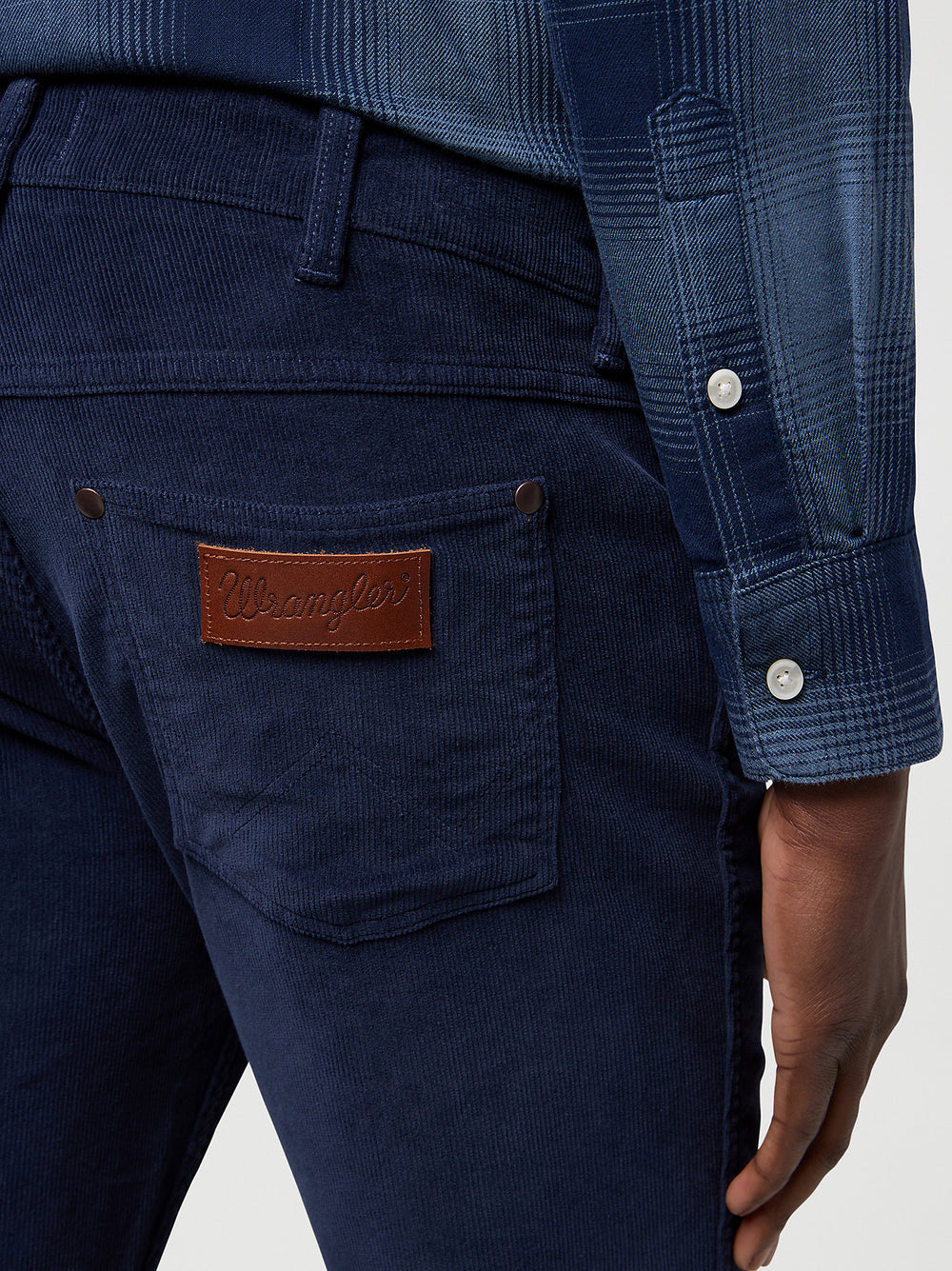 Navy blue pants with a leather patch on the pocket, worn by a person.