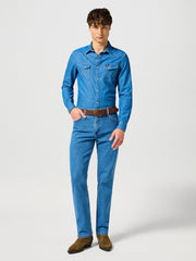 Man wearing a blue denim shirt and jeans on a white background