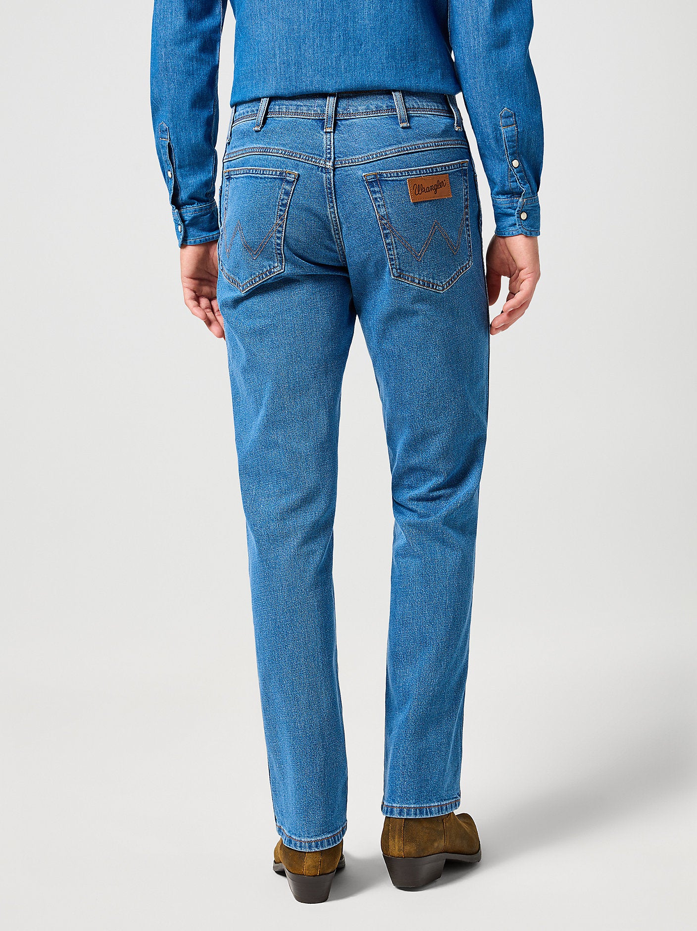 Person wearing blue jeans on a white background