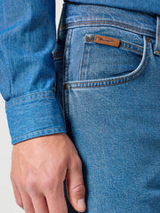 Close-up of blue jeans with a brand label on a plain background
